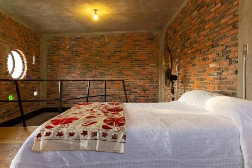 uma cama num quarto com uma parede de tijolos em Bella Casita em Querétaro
