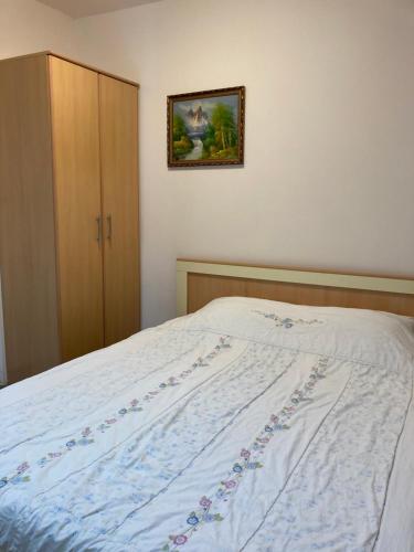 a bed in a bedroom with a picture on the wall at Mijovic Apartments in Budva