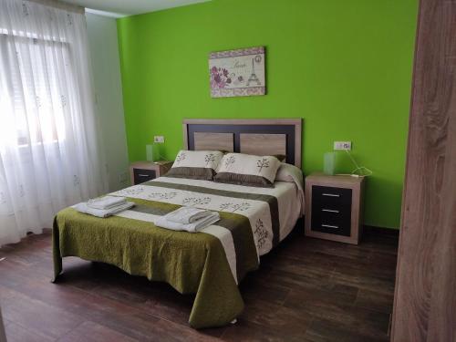 Ponte Do PortoにあるRO Apartamentos Pampin Ponte Do Portoの緑のベッドルーム(ベッド1台、ナイトスタンド2台付)