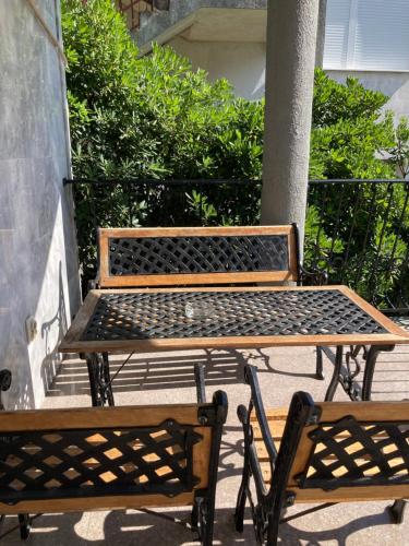 two benches and a table on a patio at Mijovic Apartments in Budva