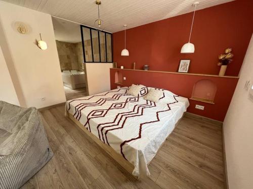 a bedroom with a large bed with a red wall at Suite romantique bohème chic avec bain à remous in La Londe-les-Maures