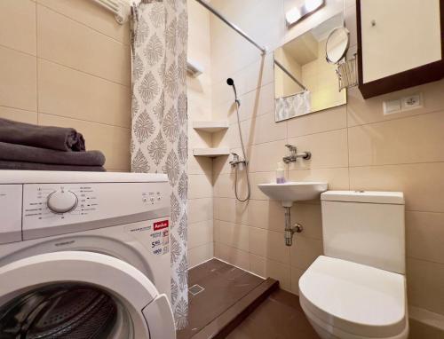uma casa de banho com uma máquina de lavar roupa e um WC em K22 Park Lazienki Aparts in Warsaw em Varsóvia