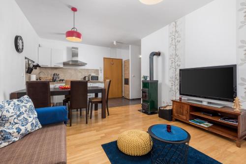 a living room with a blue couch and a tv at Nora in Mrkopalj