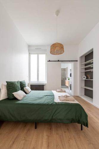 une chambre blanche avec un grand lit vert dedans dans l'établissement Le Solfé -Magnifique T2, à Lille