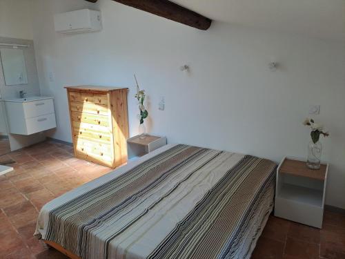 1 dormitorio con 1 cama grande y puerta de madera en Maison de vacances, en Florensac