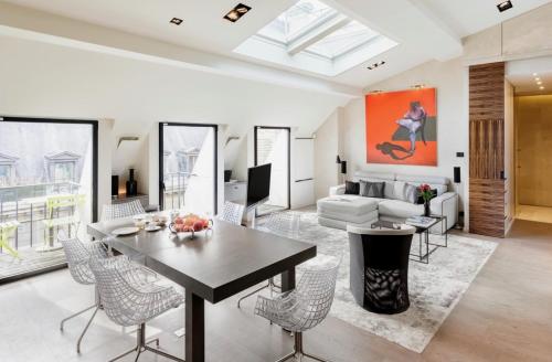 a living room with a table and chairs and a couch at Prestige sur Louvre et Tuileries in Paris