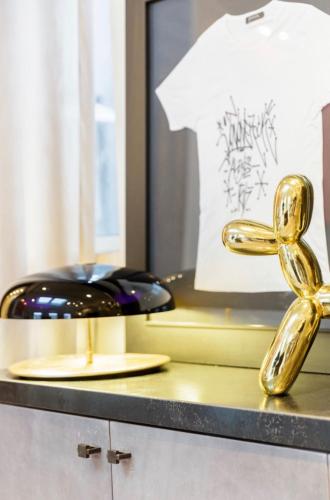 une statue en or sur un comptoir à côté d'un téléphone dans l'établissement Prestige sur Louvre et Tuileries, à Paris