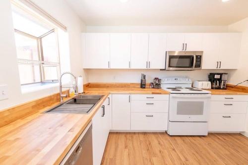 a kitchen with white cabinets and a sink at Newly Remodeled Family Friendly Home in Page