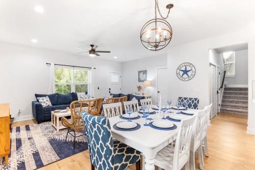 uma sala de jantar e sala de estar com uma mesa branca e cadeiras em Serenity Pearl Escape em St. Augustine
