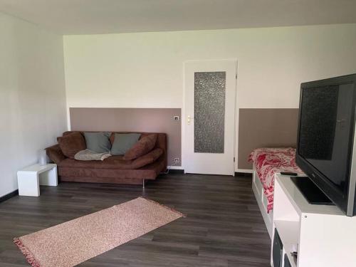 a living room with a couch and a flat screen tv at Liebevolles Appartement-Erholung pur in Bad Sachsa in Bad Sachsa