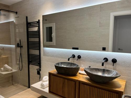 a bathroom with two sinks on a wooden counter at Seaport Llançà in Llança