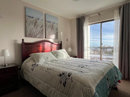 1 dormitorio con cama y ventana grande en Reñaca Departamento Holiday Park 605 cómodo y buena ubicación familiar, en Viña del Mar
