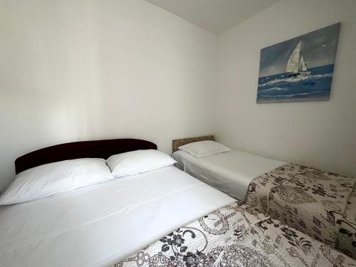 - une chambre avec 2 lits et un tableau mural dans l'établissement Apartments Villa Anna Sonia, à Podstrana