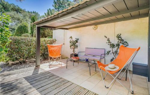 a patio with orange chairs and a table at Lovely Home In Sainte-Marie-De-Ré in La Flotte