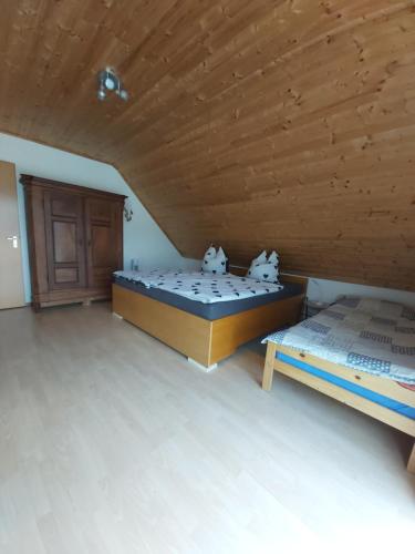 two beds in a room with a wooden ceiling at tAllhouse in Eggolsheim