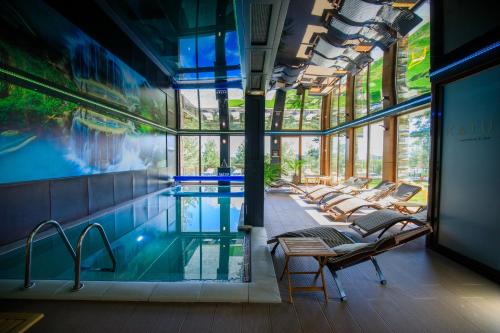 a swimming pool with lounge chairs and a swimming pool at KATUN Apartmani & SPA in Divčibare