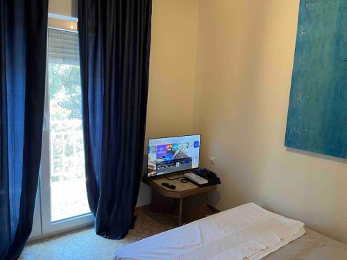 een slaapkamer met een computer op een bureau naast een raam bij Nectarios seaside apartment. in PalaiónTsiflíkion