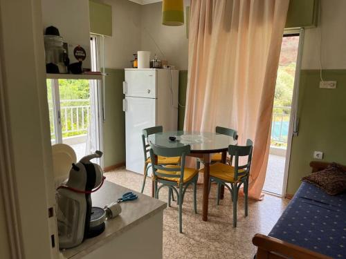 eine Küche mit einem Tisch und Stühlen in der Unterkunft Nectarios seaside apartment. in Palaió Tsiflíki