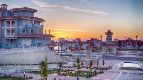 a building with a sunset in the background at Relax Unit In Porto Sharm Resort in Sharm El Sheikh