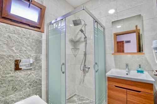La salle de bains est pourvue d'une douche et d'un lavabo. dans l'établissement Nirvana Boutique Hotel, à Datça