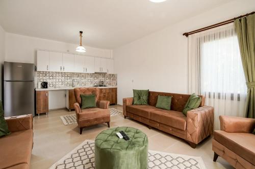 a living room with brown furniture and a kitchen at Nirvana Boutique Hotel in Datca