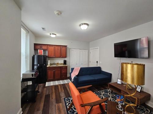 a living room with a blue couch and a kitchen at Luxurious 1 Bed 1 Bath Stay at the Historic Inman in Champaign
