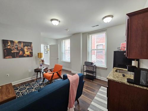 un salon avec un canapé bleu et une télévision dans l'établissement Luxurious 1 Bed 1 Bath Stay at the Historic Inman, à Champaign