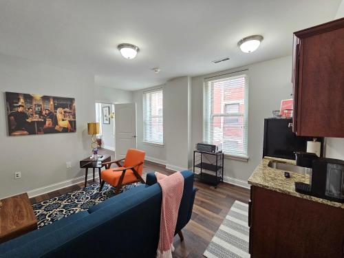 a living room with a blue couch and a tv at Luxurious 1 Bed 1 Bath Stay at the Historic Inman in Champaign