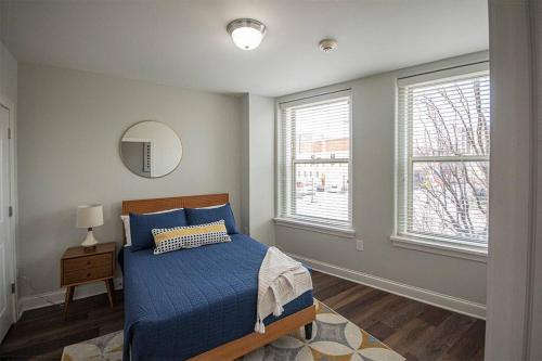a bedroom with a bed and two windows at Stylish 1 BR 1BA at The Inman in Champaign