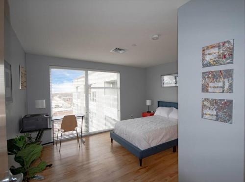 um quarto com uma cama, uma secretária e uma janela em Luxury Condo in Downtown Champaign em Champaign
