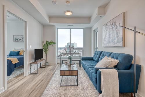 a living room with a blue couch and a tv at 2 Bedroom, 2 Bath Stunning Condo - heart of Kitchener Downtown in Kitchener