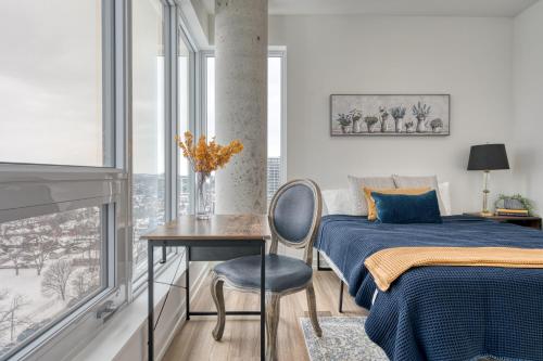 a bedroom with a bed and a table and a chair at 2 Bedroom, 2 Bath Stunning Condo - heart of Kitchener Downtown in Kitchener
