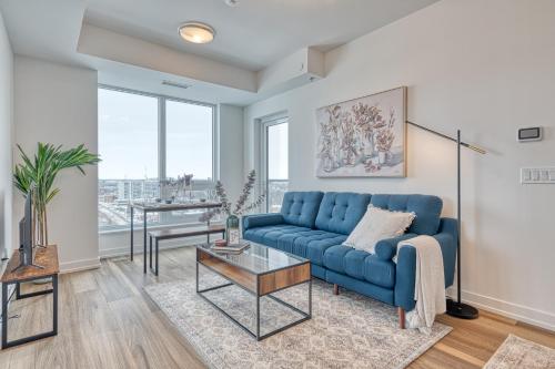 a living room with a blue couch and a table at 2 Bedroom, 2 Bath Stunning Condo - heart of Kitchener Downtown in Kitchener