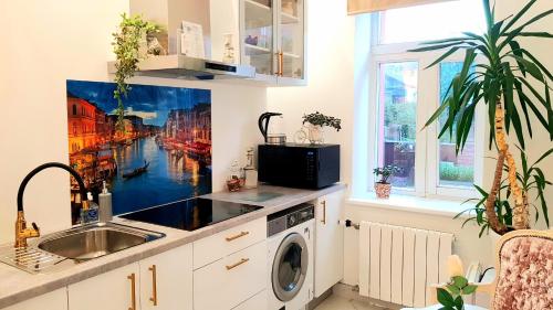 a kitchen with a sink and a washing machine at Hotel Jugend with Self Check-in in Liepāja