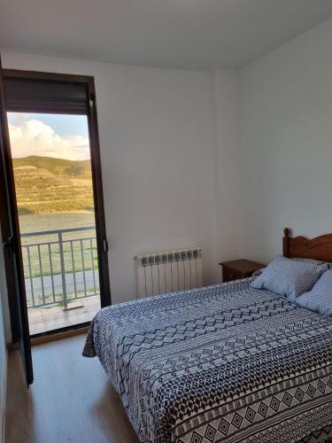 a bedroom with a bed and a large window at Albergue Valmadrid in Valmadrid
