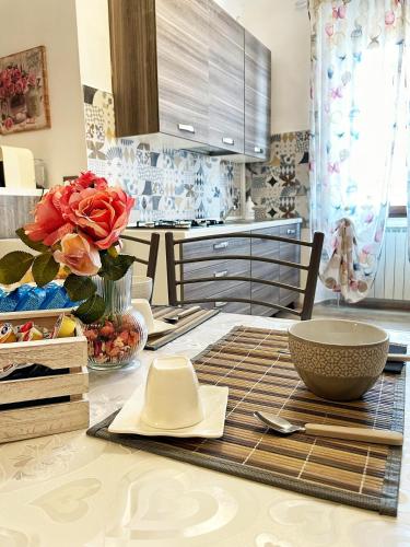 a kitchen with a table with a vase of roses on it at La dimora di Sandy in Viterbo