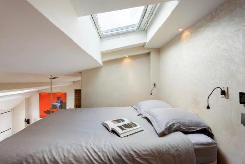 a bedroom with a large bed and a skylight at Prestige sur Louvre et Tuileries in Paris