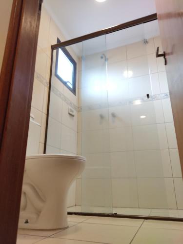 a bathroom with a toilet and a glass shower at Jaguaré Hotel in Sao Paulo