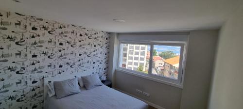 1 dormitorio con cama y ventana en Vigo al Mar, en Vigo