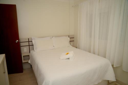 ein weißes Bett mit einem Handtuch darüber in der Unterkunft Micasa Di Canela in Canela