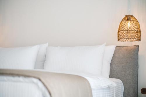 a white bed with white pillows and a lamp at KAAB Boutique Hotel in Ulcinj