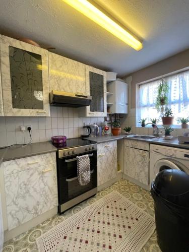 a kitchen with a stove top oven next to a window at Dream Room in London