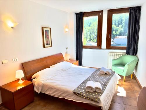 a bedroom with a bed and a chair and a window at [Paradiso di Montagna sulle piste da sci] in Bardonecchia