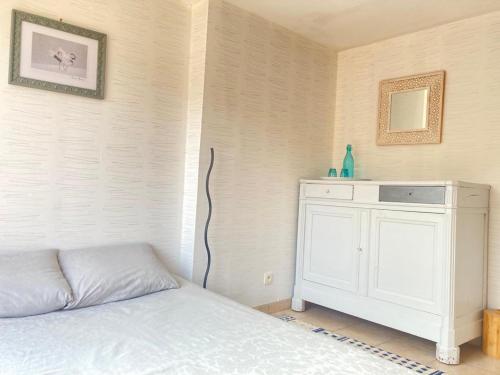 a bedroom with a bed and a white cabinet at Le Cocon in Verrières