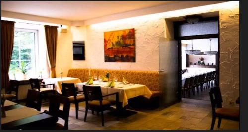 a dining room with two tables and chairs in a restaurant at Hotel zum Markgrafen in Lüdenscheid