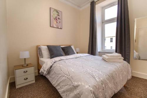 Un dormitorio con una cama grande y una ventana en The Ojay's - Gustina Apartment en Aberdeen