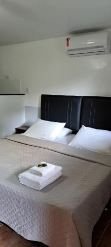 a white towel sitting on top of a bed at Recanto das Flores Lofts - Ilha Grande Rj in Abraão