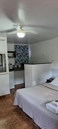 een slaapkamer met een bed en een plafondventilator bij Recanto das Flores Lofts - Ilha Grande Rj in Abraão