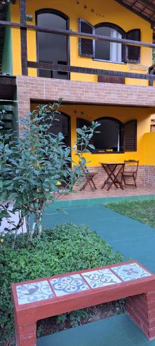 a red bench sitting in front of a building at Recanto das Flores Lofts - Ilha Grande Rj in Abraão