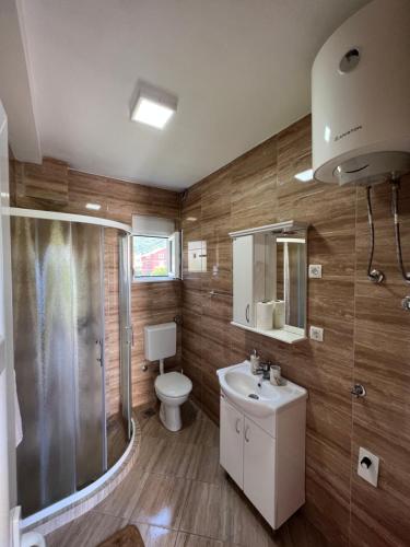 a bathroom with a toilet and a shower and a sink at Apartment Kovach Kuti in Herceg-Novi
